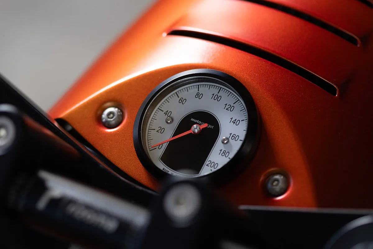Velocímetro Motogadget Motoscope Tiny empotrado en el faro naranja con ranuras de ventilación de la BMW R100/7