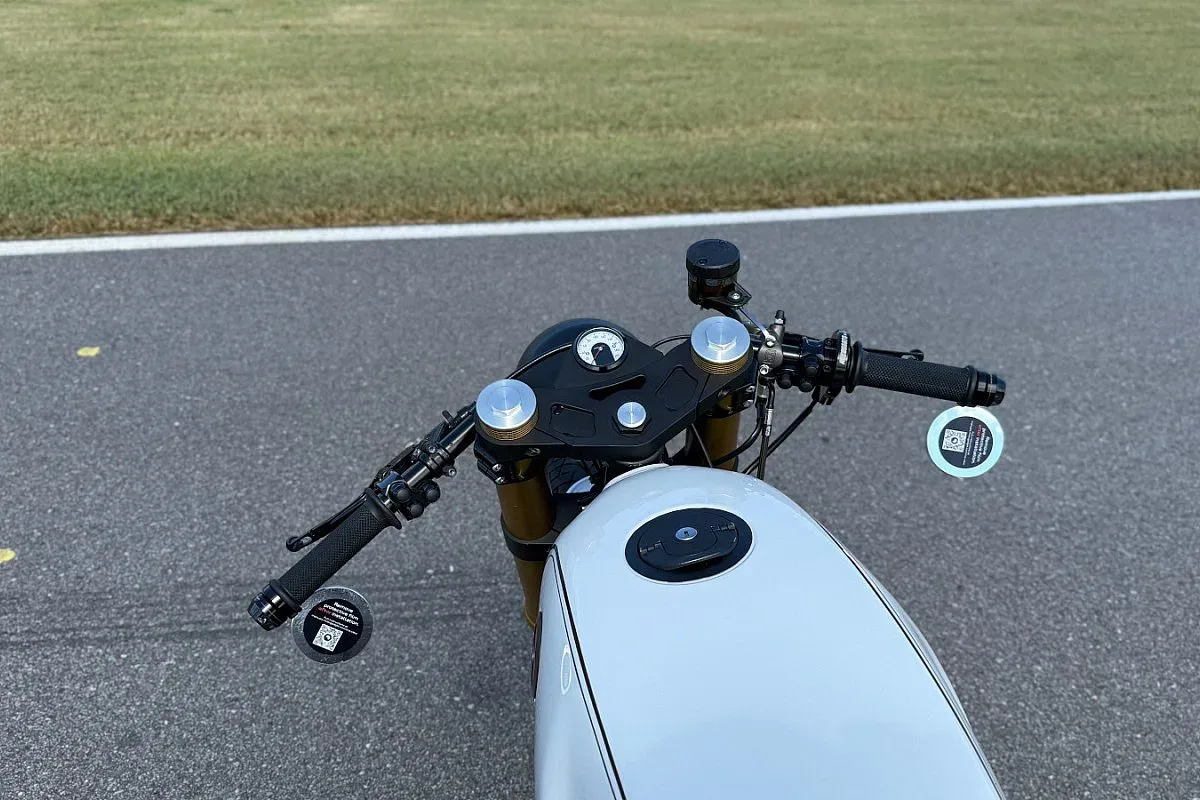 Vista desde arriba de los semimanillares, el velocímetro Motogadget y el depósito blanco de la BMW R100 de Marekswerk