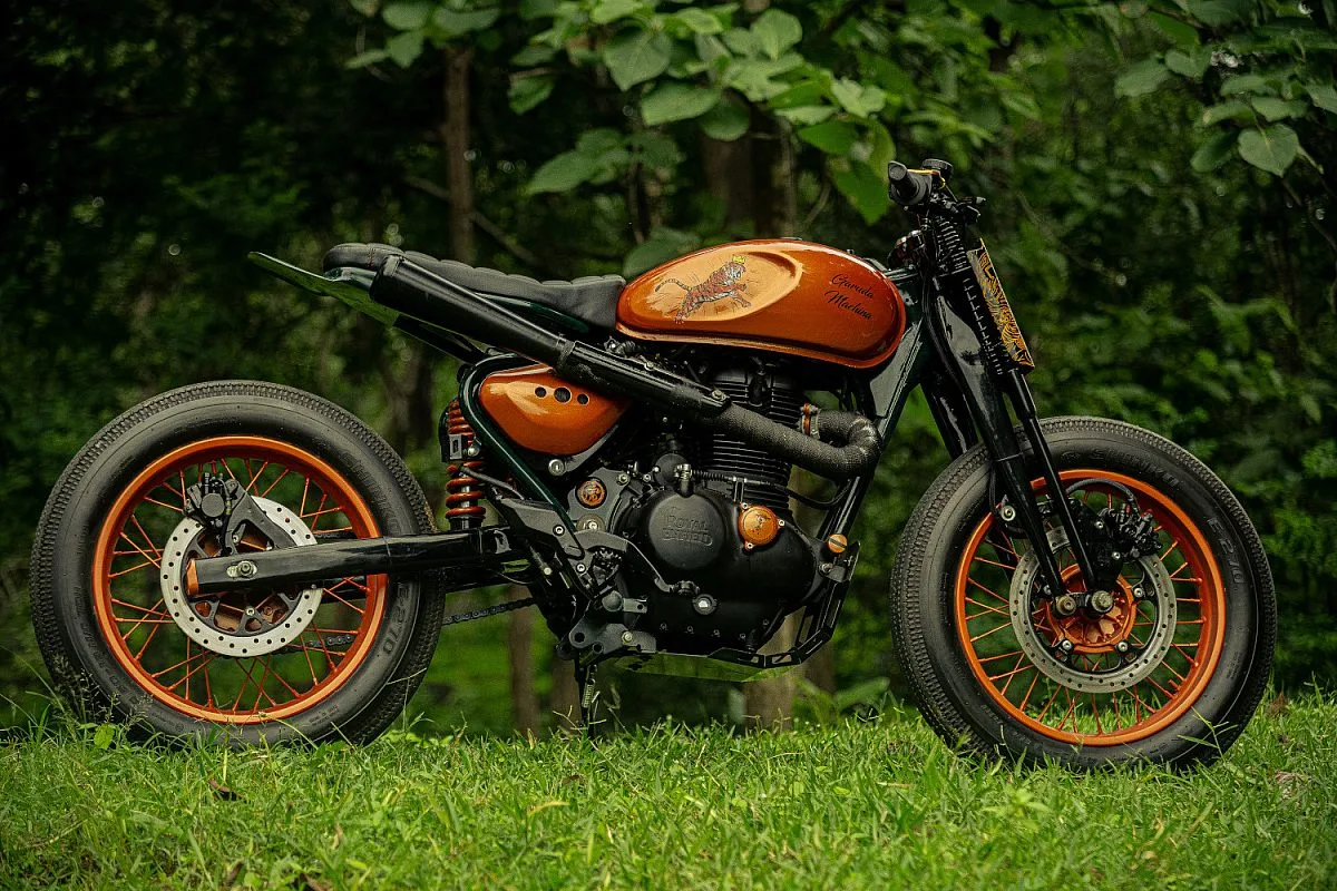 Royal Enfield Hunter 350 convertida en street tracker por Garuda Machina, vista lateral: depósito naranja con tigre pintado, llantas de radios naranjas y neumáticos Shinko E270
