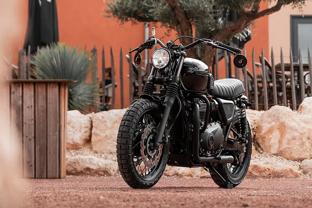 Triumph Bonneville T120 de FCR Original en tres cuartos delanteros, con faro Bates, manillar negro con intermitentes en los extremos y neumáticos Pirelli Scorpion