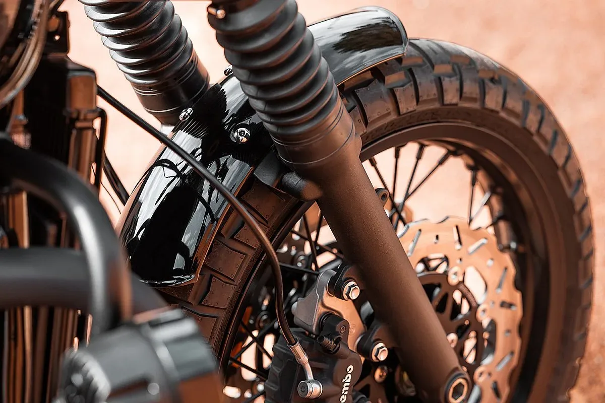 Guardabarros delantero negro brillante de aluminio de la Triumph T120, con la barra de horquilla tratada y la pinza Brembo sobre el disco de freno